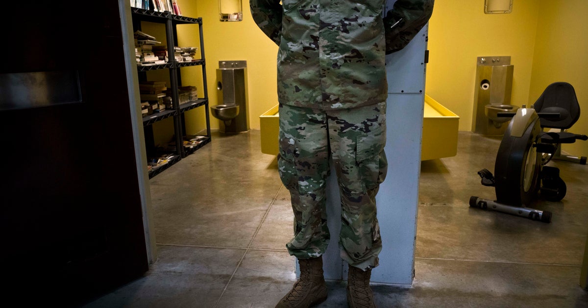 In this photo reviewed by U.S. military officials, a U.S. soldier stands between two cells, one used as a library and the other a gym, inside the Camp VI detention facility at the Guantanamo Bay U.S. naval base in Cuba on June 6, 2018.