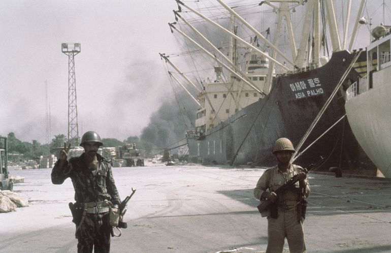 Iraqi forward troops stand guard over shipping at the dockside in occupied Khorramshahr, Iran on Oct. 7, 1980. (AP Photo)