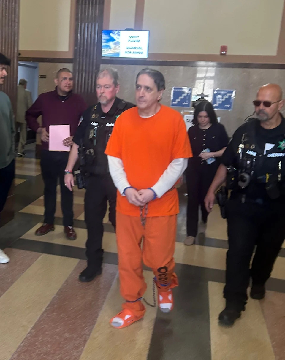 Murder defendant Richard Glossip is escorted from a hearing in Oklahoma County District Court on May 13. Behind him is his wife, Lea Glossip