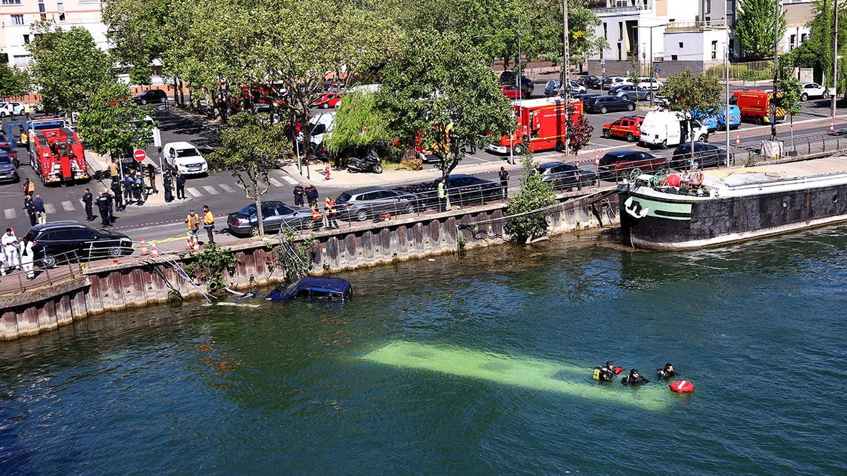French emergency services and firefighters working near a bus submerged in the River Seine