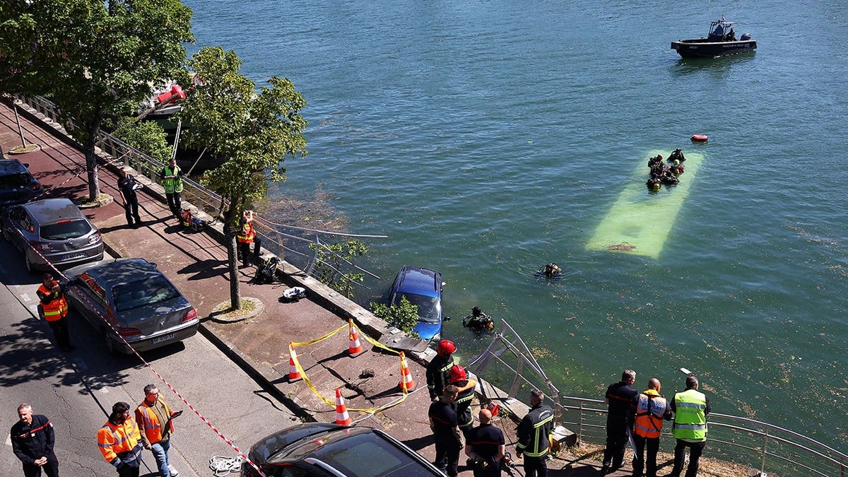 French emergency services and firefighters working near a bus in the River Seine