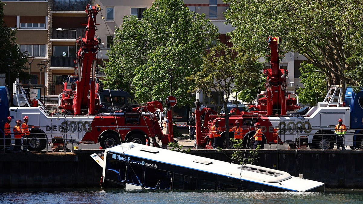Workers recovering a bus from the River Seine in Juvisy-sur-Orge near Paris