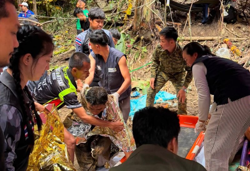 Rescue team members wrap a thermal blanket around one of the four men brought out from the semi-submerged cave in Xaysomboun province of Laos on Saturday afternoon. (Photo: Thailand Rescue Diver Facebook)