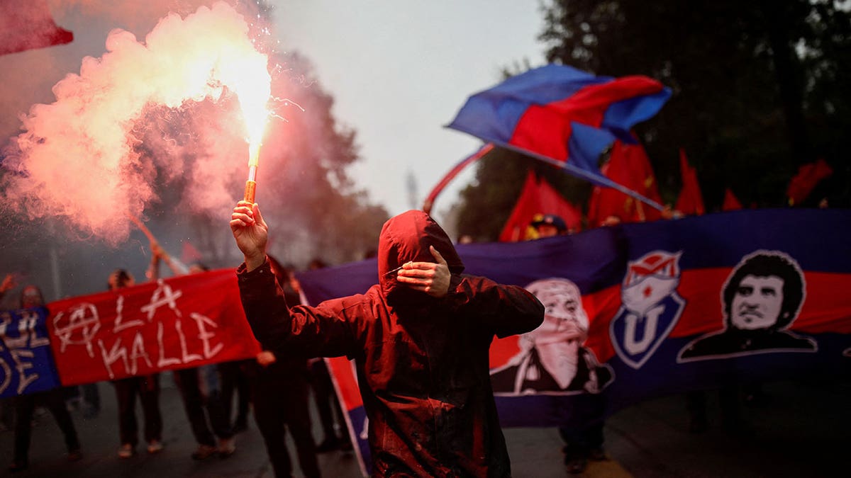 Crowd of people marching with Chilean flags during May Day event