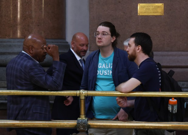 Austin Busch, state advocacy coordinator for YIMBY Illinois, center right, talks with colleagues outside the House chamber during the spring legislative session at the State Capitol, May 30, 2026, in Springfield. (John J. Kim/Chicago Tribune)
