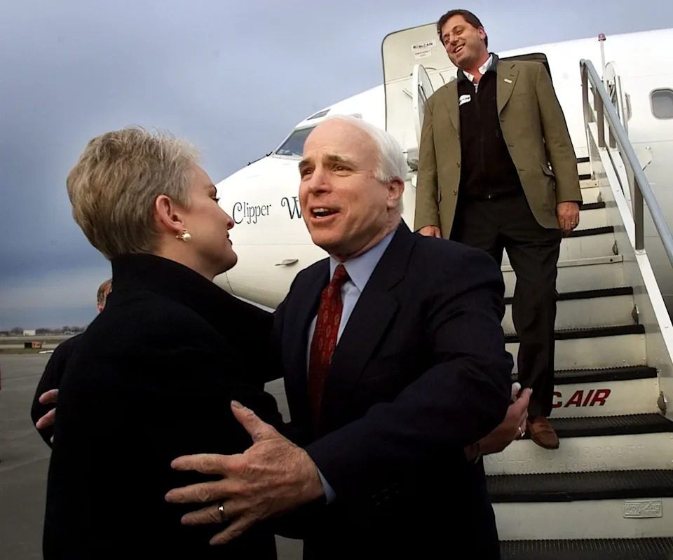 Sen. John McCain reaches out to his wife Cindy are flanked by son, Doug McCain, as the then-Republican presidential candidate arrives in Syracuse, New York on March 4, 2000.