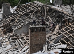 Ukrainian rescuers work at the site of an apartment building hit by a Russian drone strike in Zaporizhzhya on May 30.