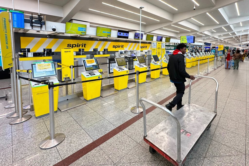 An airport employee passes the Spirit Airlines counter at Hartsfield-Jackson Atlanta International Airport after the carrier shut down on Saturday. Photo: AP