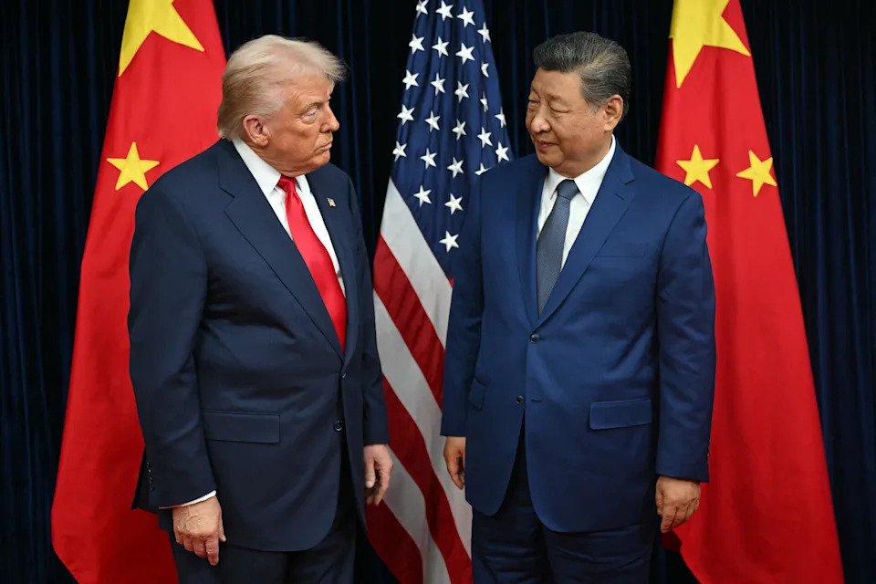 President Trump and Chinese President Xi Jinping standing next to each other, with flags of their respective countries in the background.