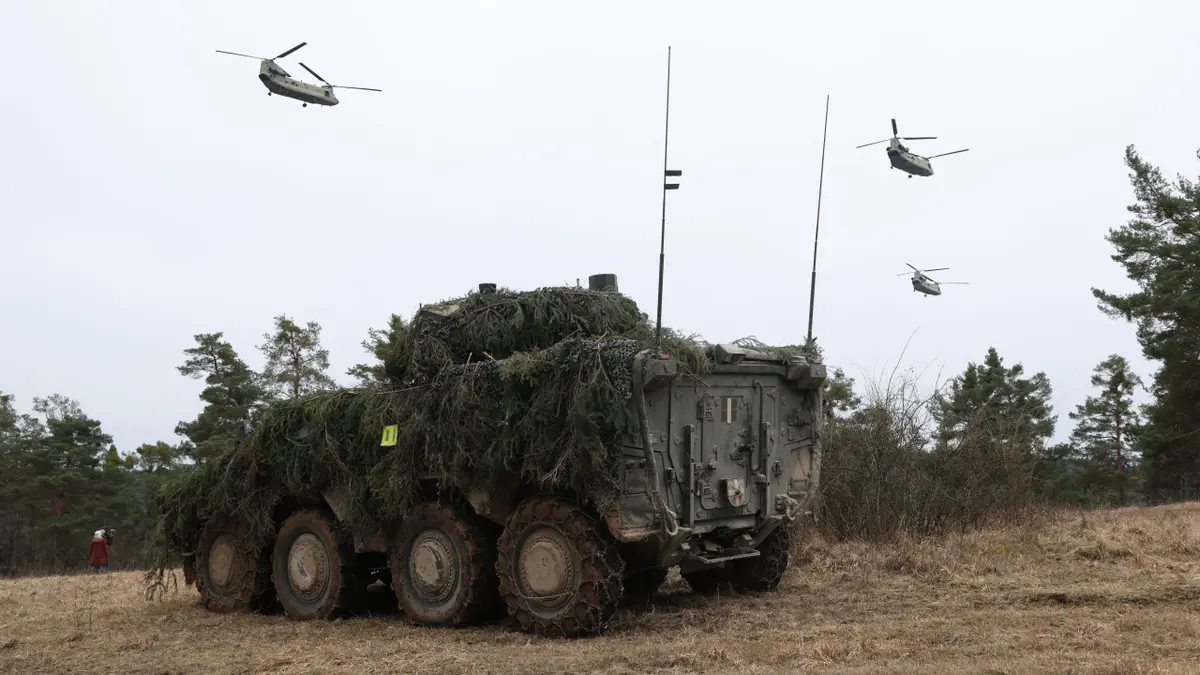 Boeing CH-47 Chinook helicopters flying over Lithuanian Vilkas infantry fighting vehicle near Hohenfels Germany