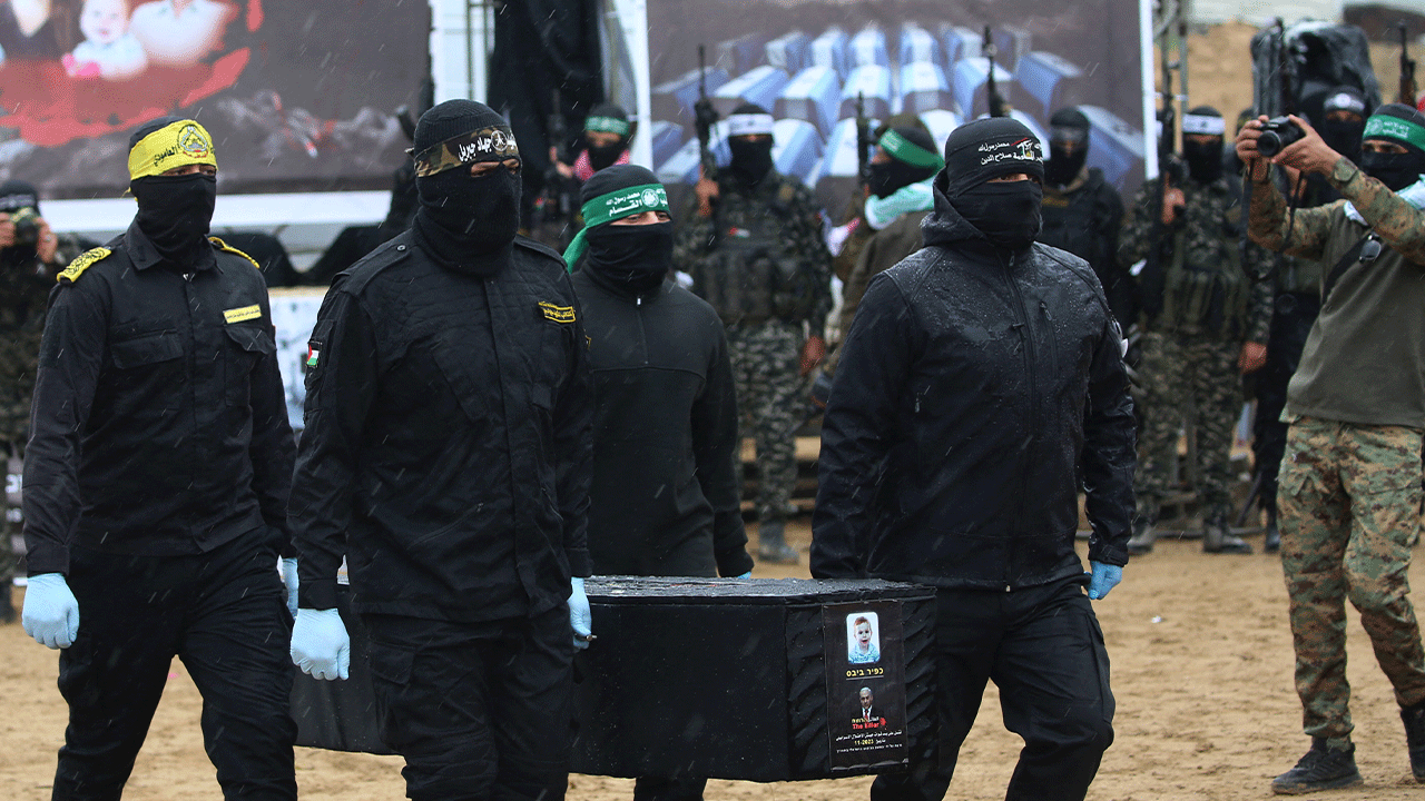 Hamas militants carrying coffins during body handover in Khan Yunis Gaza