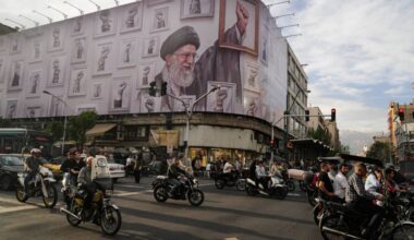 Motorbikes drive past a billboard with graphic showing the late Iranian Supreme Leader Ayatollah Ali Khamenei, who was killed in the U.S. and Israel strikes on Feb. 28, with his framed fist amongst his supporters framed fists in downtown Tehran, Iran, Wednesday, May 6, 2026. (AP Photo/Vahid Salemi)