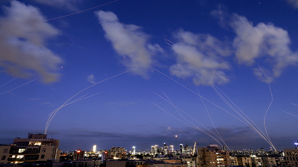 Iron Dome missile defense system intercepting projectiles over Tel Aviv at night