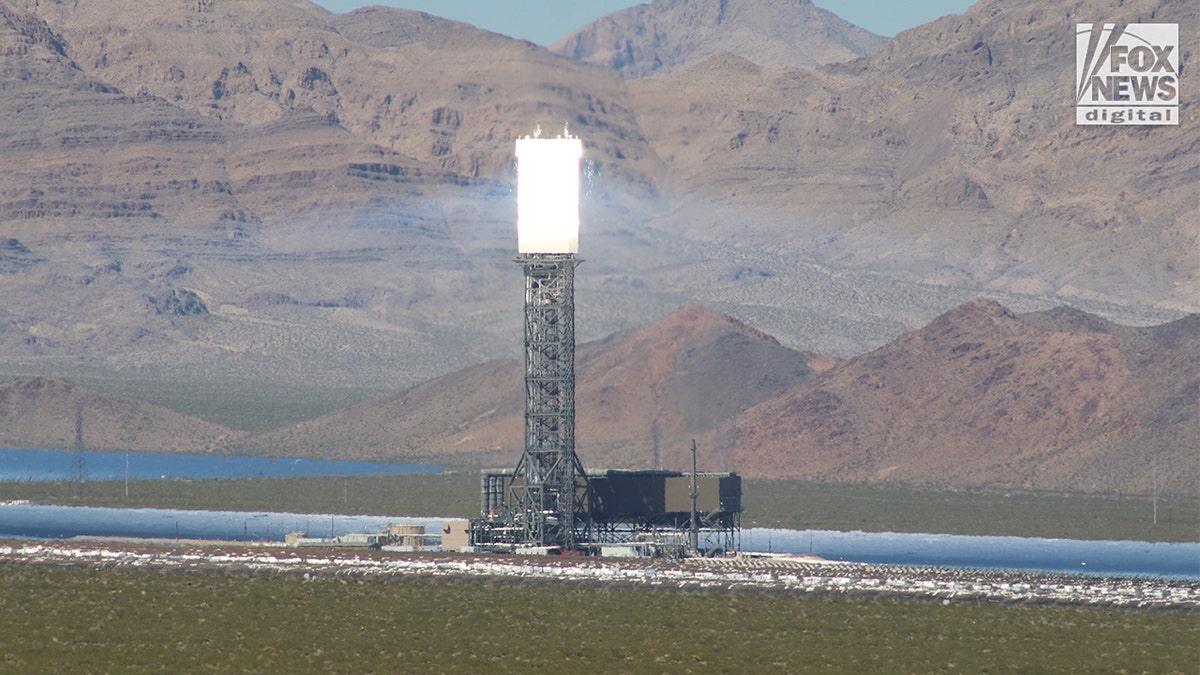 Close-up of Ivanpah solar tower glowing with reflected sunlight in desert