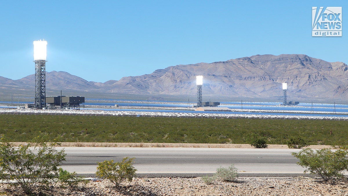 Three illuminated towers at Ivanpah solar plant in California desert