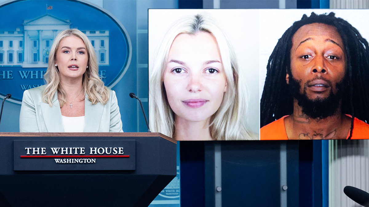 White House Press Secretary Karoline Leavitt speaking at a press briefing with photos of Iryna Zarutska and Decarlos Brown Jr. projected behind her