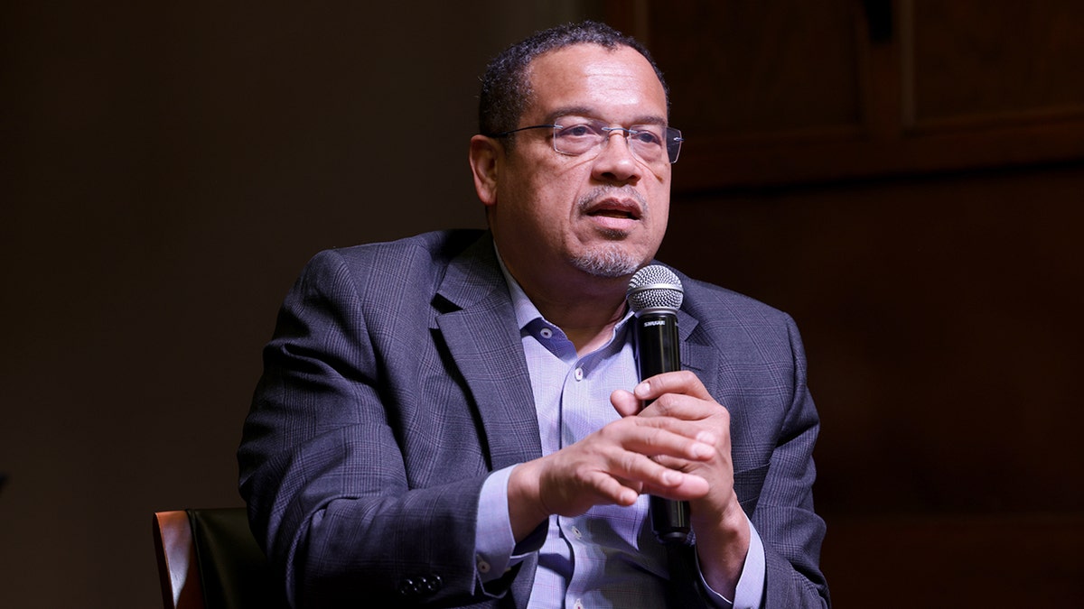 Minnesota Attorney General Keith Ellison speaking at a microphone indoors