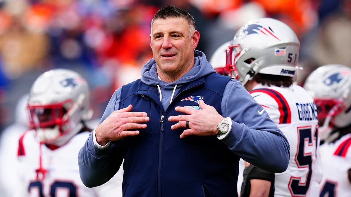 New England Patriots head coach Mike Vrabel standing on the field at Empower Field at Mile High