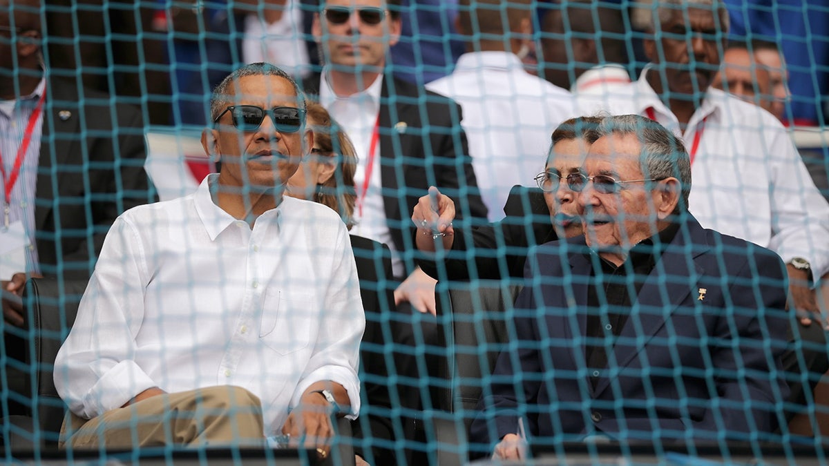 U.S. President Barack Obama and Cuban President Raul Castro standing together at a baseball game in Havana