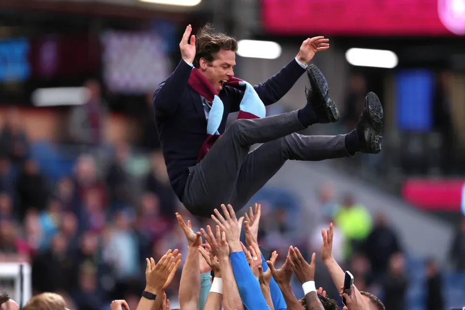 The players of Burnley lift Scott Parker, Manager of Burnley, into their air as they celebrate victory and subsequent promotion to the Premier League following the Sky Bet Championship match between Burnley FC and Sheffield United