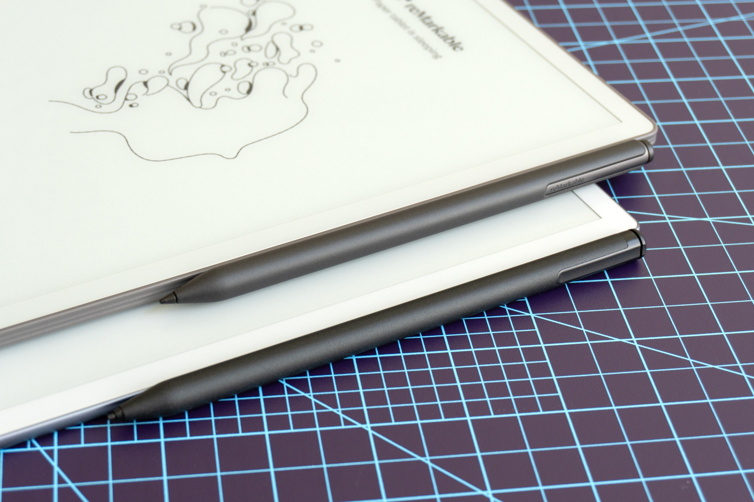 The Remarkable Paper Pure sitting on top of the Remarkable 2 tablets highlighting their attached stylii.