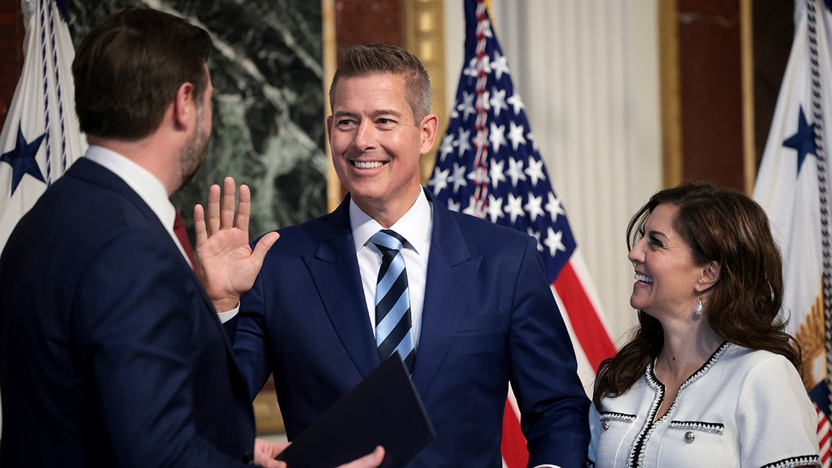 Secretary of Transportation Sean Duffy raising his hand while being sworn in by Vice President JD Vance with Rachel Campos-Duffy holding a Bible