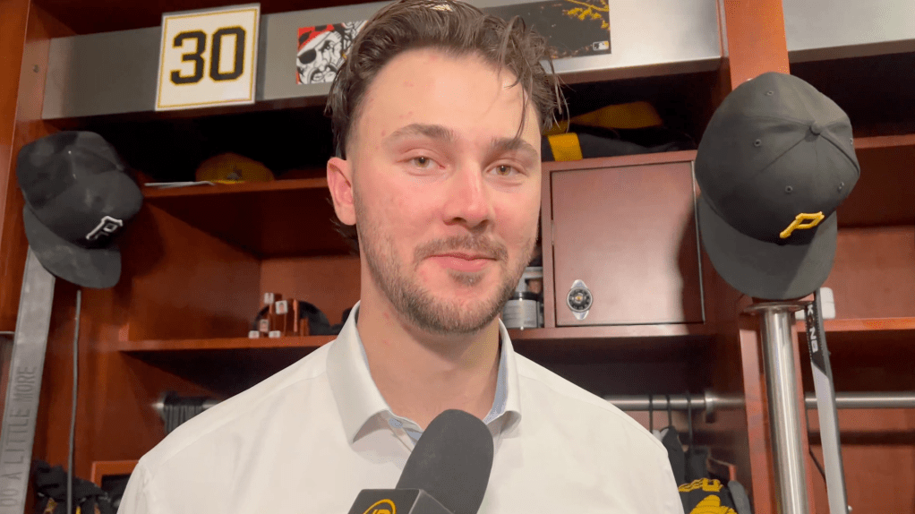 Man being interviewed in a locker room with a "30" sign in the background.