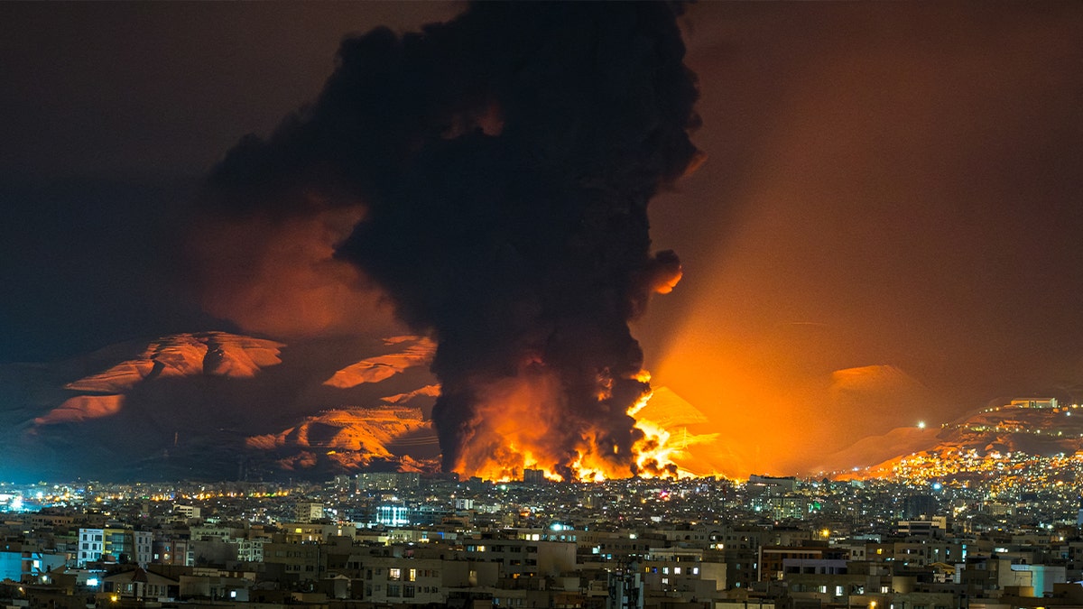 Smoke and flames rise at the site of airstrikes on an oil depot in Tehran