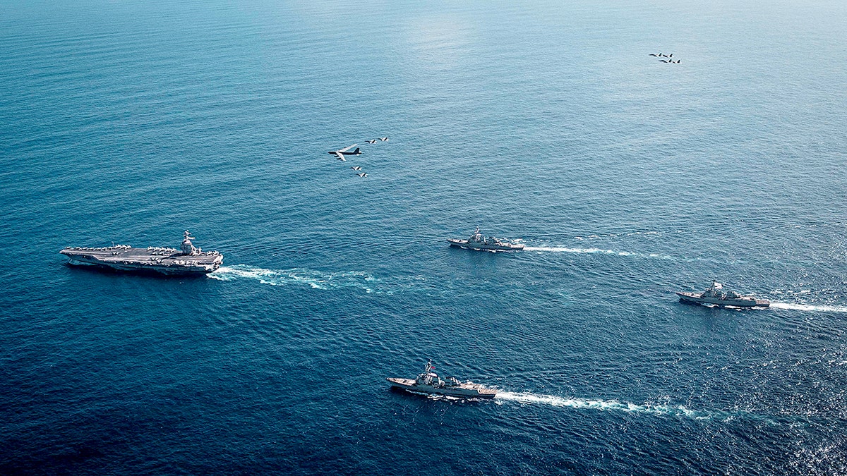 USS Gerald R. Ford Carrier Strike Group sailing in the Atlantic Ocean with military planes overhead
