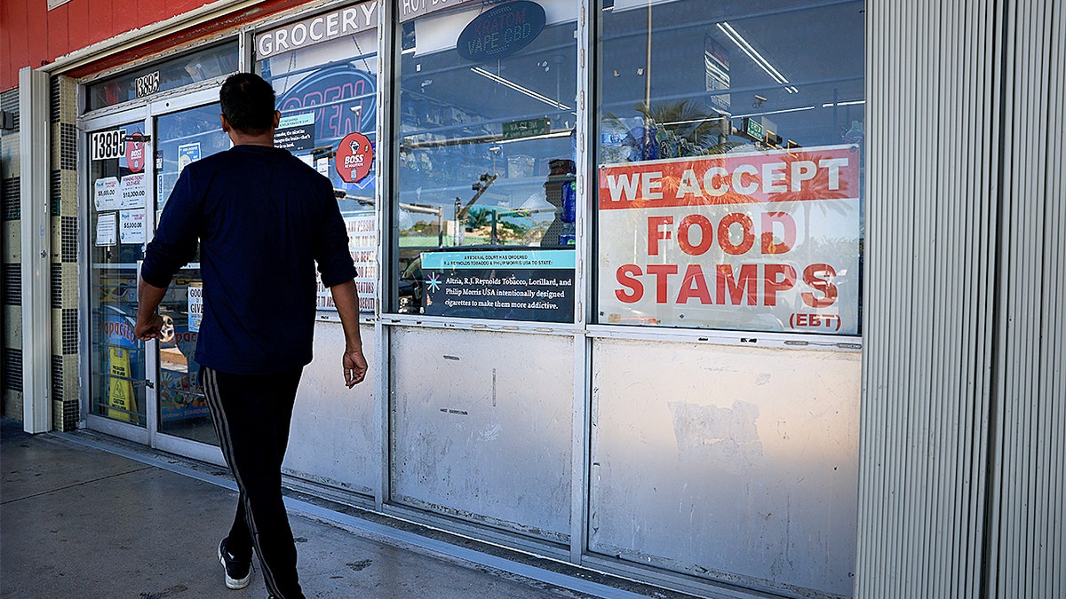 A We Accept Food Stamps sign hanging in a grocery store window in Miami