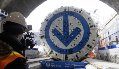 A tunnel borer with a blue and white métro logo painted on its cutting surface is seen at the entrance to a tunnel from inside the tunnel.
