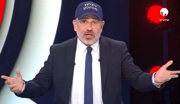 Right-wing pundit Yinon Magal on pro-Netanyahu Channel 14, wearing a hat reading "total victory."