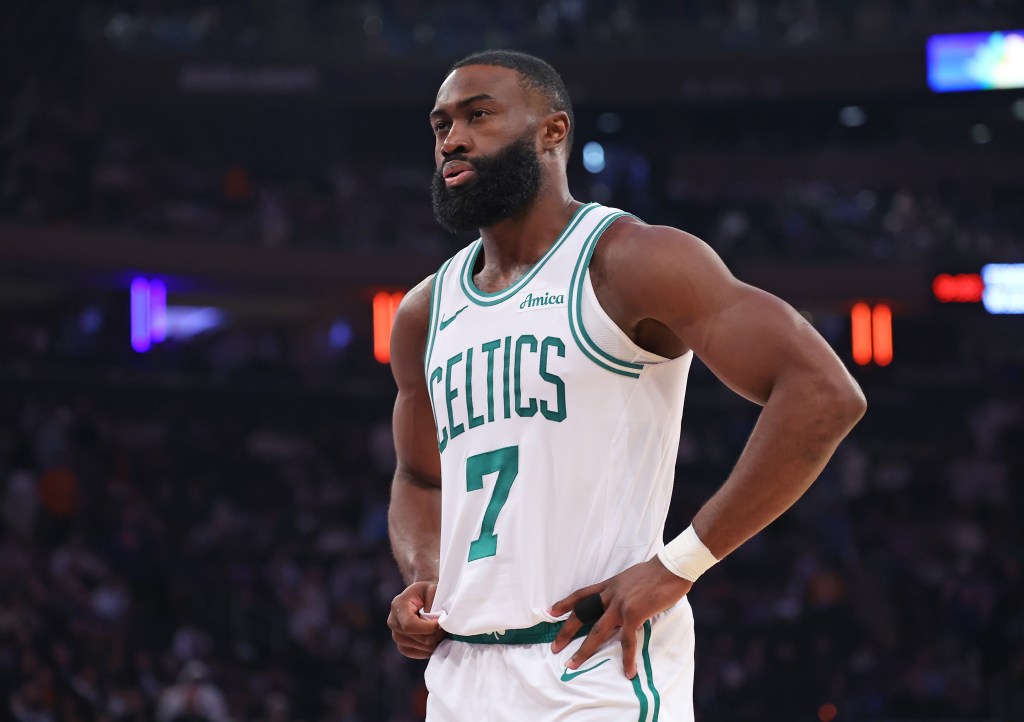 Jaylen Brown of the Boston Celtics wearing a white jersey with green trim and the number 7, hands on hips, looking intently to the left.