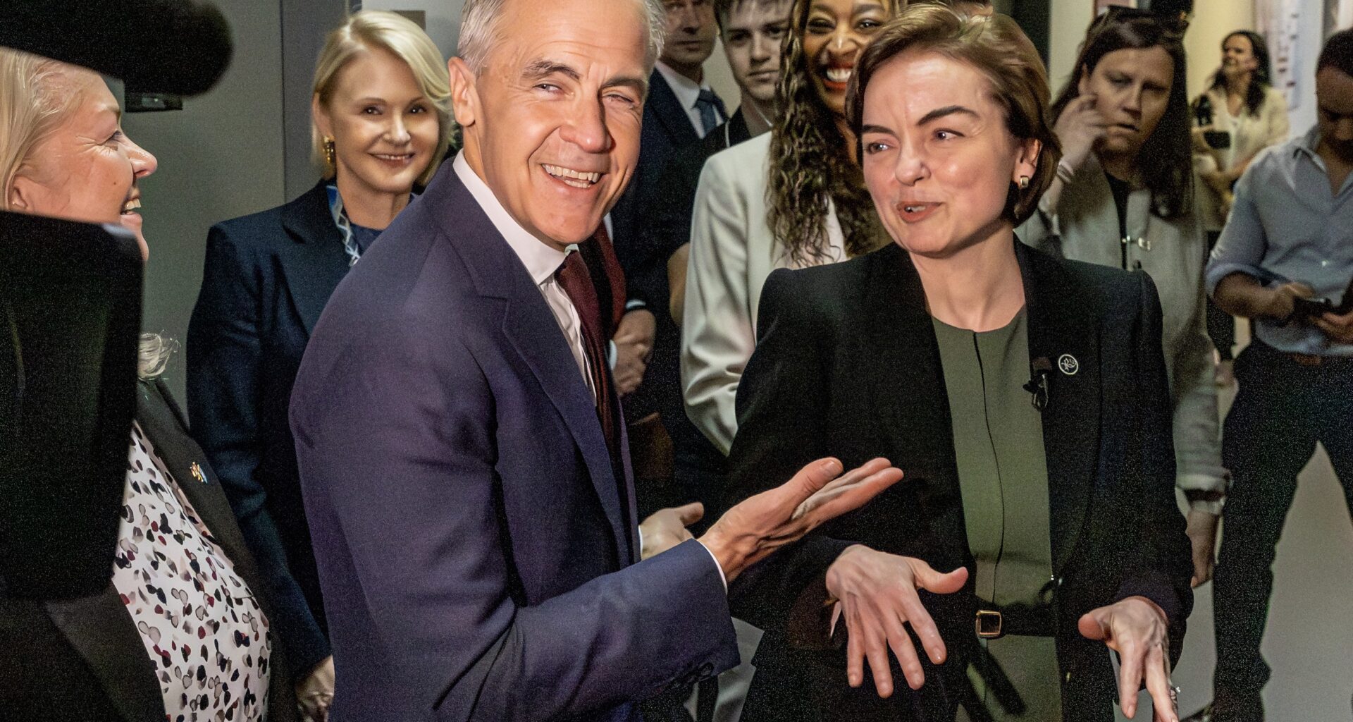 Mark Carney and Christine Fréchette in a hallway full of people.