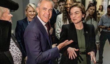 Mark Carney and Christine Fréchette in a hallway full of people.
