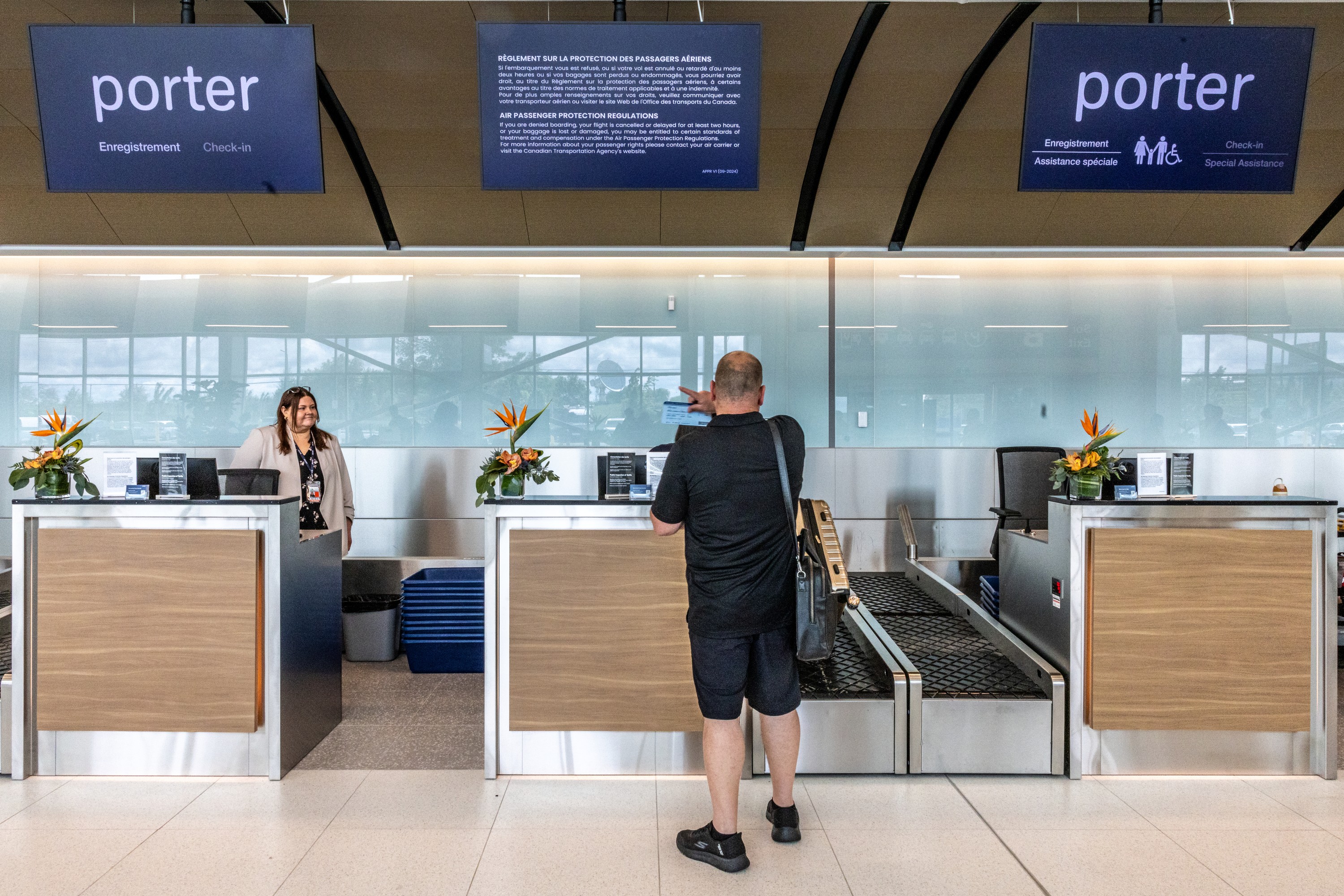 A man is seen from behind at a Porter Airlines check-in counter.