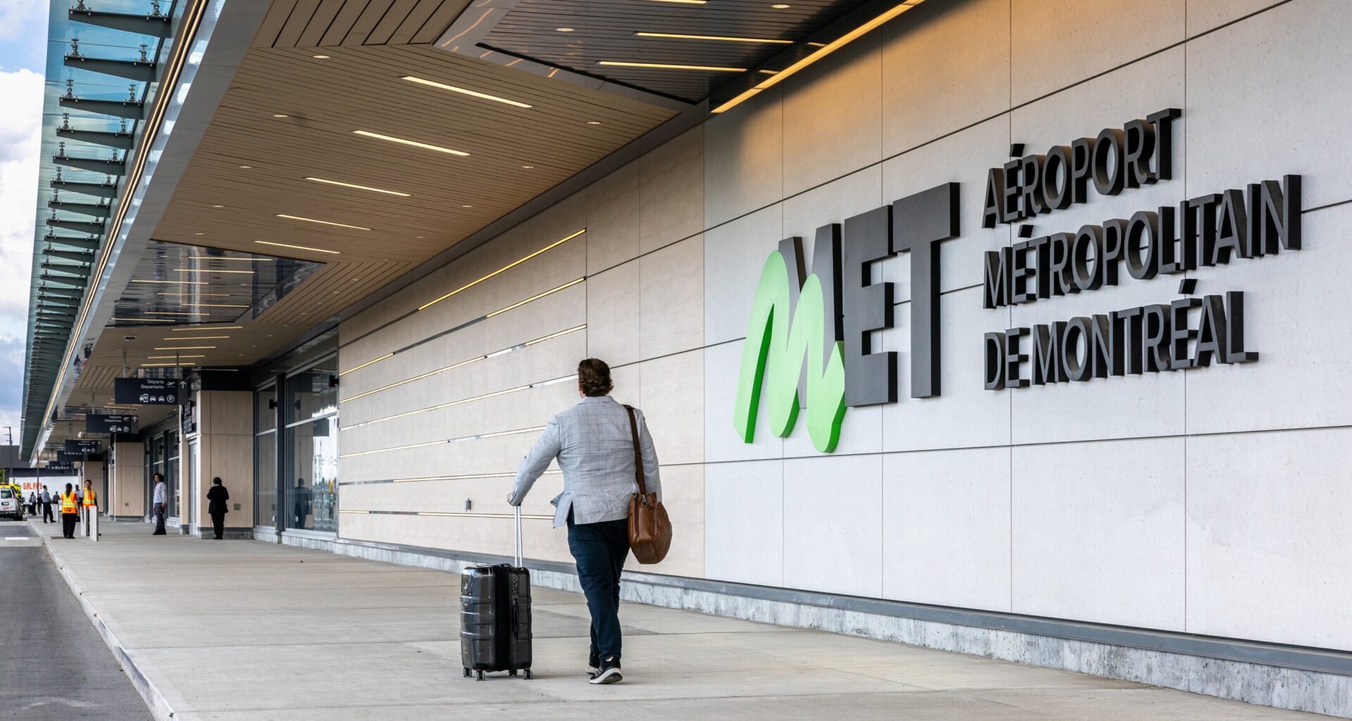 A traveller wheels a suitcase outside the Montreal Metropolitan Airport in St-Hubert.