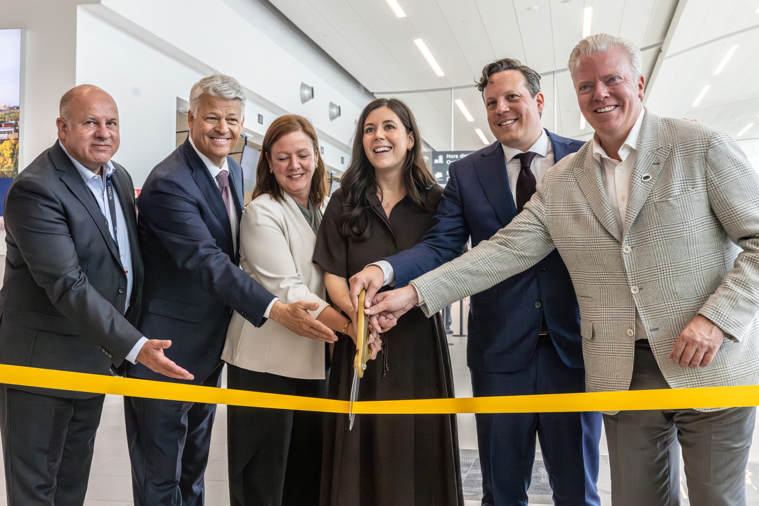 Yani Gagnon, co-owner and vice-president, Pascan Aviation; Charles Roberge, president and chief executive officer, YHU Terminal; Quebec Tourism Minister Amélie Dionne; Longueuil Mayor Catherine Fournier; Simon-Pierre Diamond, Montreal Metropolitan Airport interim president; and Porter Airlines CEO Michael Deluce cut a yellow ribbon at the St-Hubert airport.