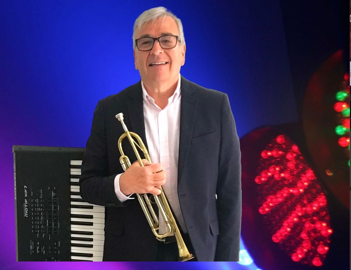 A man in a suit with musical instruments nearby