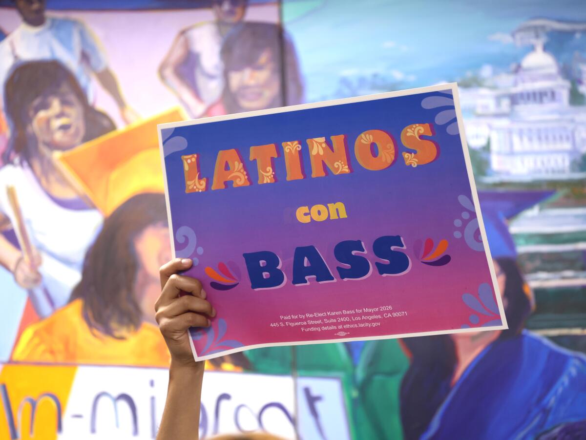 A man holds up a sign in support of Mayor Karen Bass.