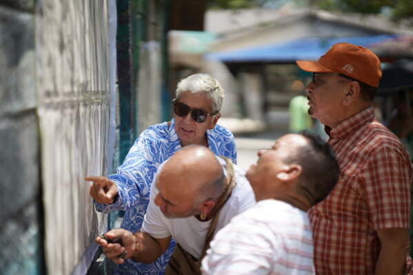 Voters check electoral lists at a polling station in Puerto Colombia, Colombia, Sunday, May 31, 2026. (AP Photo/Ivan Valencia)