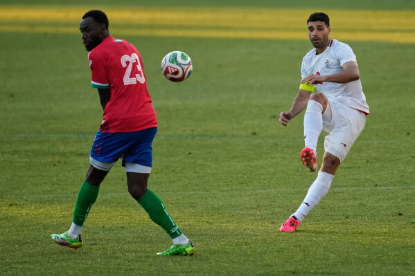 Iran's Mehdi Taremi, right, shoots the ball next to Gambia's Mouhamadou Drammeh during a friendly soccer match between Iran and Gambia, in Antalya, southern Turkey, Friday, May 29, 2026. (AP Photo/Khalil Hamra)