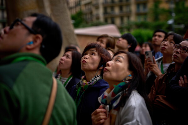 Visitors admire one of the façades of Antoni Gaudí's Basilica of the Sagrada Familia in Barcelona, Spain, Friday, May 15, 2026, ahead of Pope Leo XIV's visit to the city in June. (AP Photo/Emilio Morenatti)
