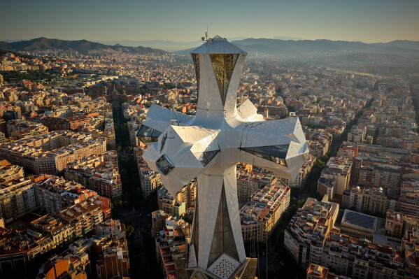 The cross crowns the 172.5-meter (566-foot) Tower of Jesus Christ at the Sagrada Familia basilica in Barcelona, Spain, Thursday, May 28, 2026, ahead of Pope Leo XIV's visit to the city in June. (AP Photo/Emilio Morenatti)
