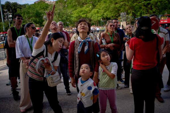 Visitors admire one of the façades of Antoni Gaudí's Basilica of the Sagrada Familia in Barcelona, Spain, Friday, May 15, 2026, ahead of Pope Leo XIV's visit to the city in June. (AP Photo/Emilio Morenatti)