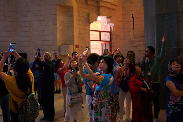 Visitors take photos inside Antoni Gaudí's Basilica of the Sagrada Familia in Barcelona, Spain, Tuesday, May 26, 2026, ahead of Pope Leo XIV's visit to the city in June. (AP Photo/Emilio Morenatti)