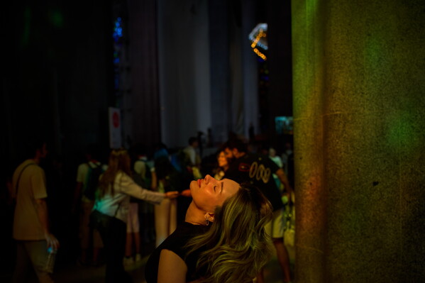 A visitor looks up inside Antoni Gaudí's Basilica of the Sagrada Familia as colored light from its stained-glass windows illuminates the interior in Barcelona, Spain, Tuesday, May 26, 2026, ahead of Pope Leo XIV's visit to the city in June. (AP Photo/Emilio Morenatti)