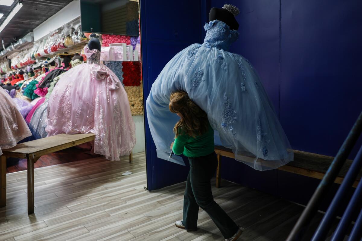 Leonor Torres hoists a dress as she closes shop after another slow day of sales.