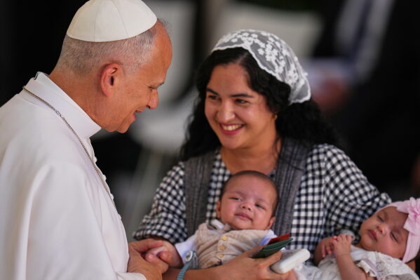 A mother and her two children are greeted by Pope Leo XIV at CEDIA 24 Horas, a comprehensive support center for homeless people, in Madrid, Spain, Saturday, June 6, 2026, on the first day of his seven-day apostolic visit to mainland Spain and the Canary Islands. (AP Photo/Manu Fernandez)