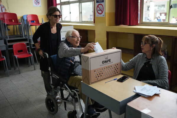 Jose Ludoweieg, 98, casts his ballot accompanied by his granddaughter, Gabriela Bellido, during the presidential runoff election in Lima, Peru, Sunday, June 7, 2026.(AP Photo/Rodrigo Abd)